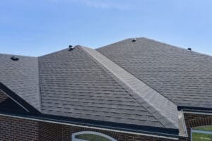 Close-up of gray asphalt shingle roof in Ferndale on brick building under clear sky