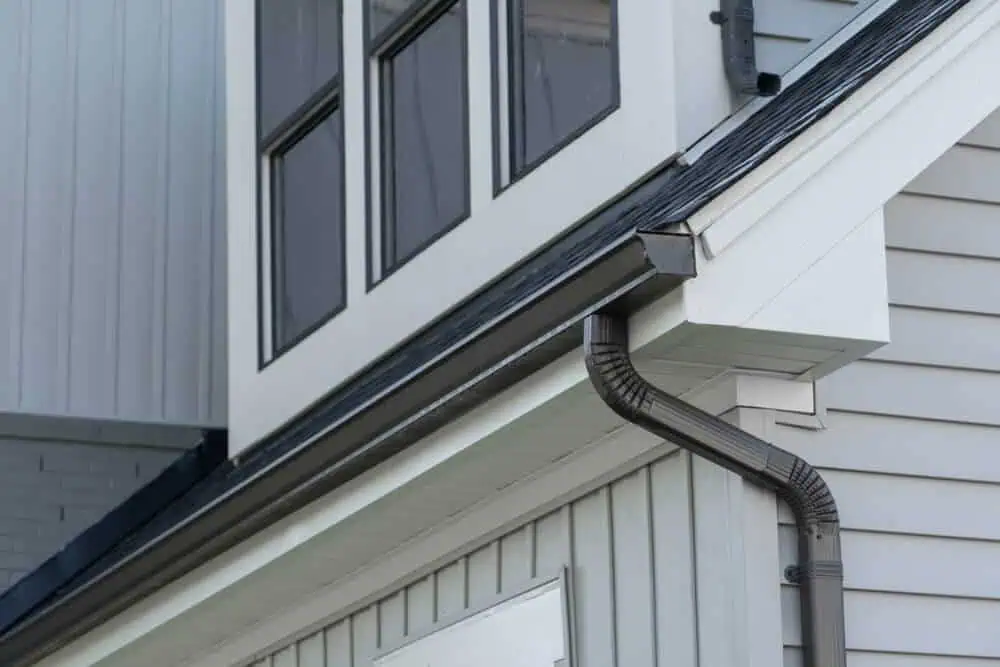 Close-up of Ferndale home's roof corner showcasing premium gutters, downspouts, and black-framed windows.