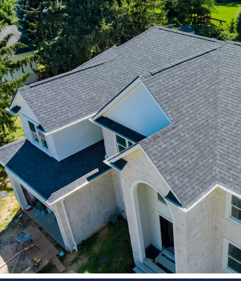 An aerial view of a house with a gray roof showcasing an exterior improvement.