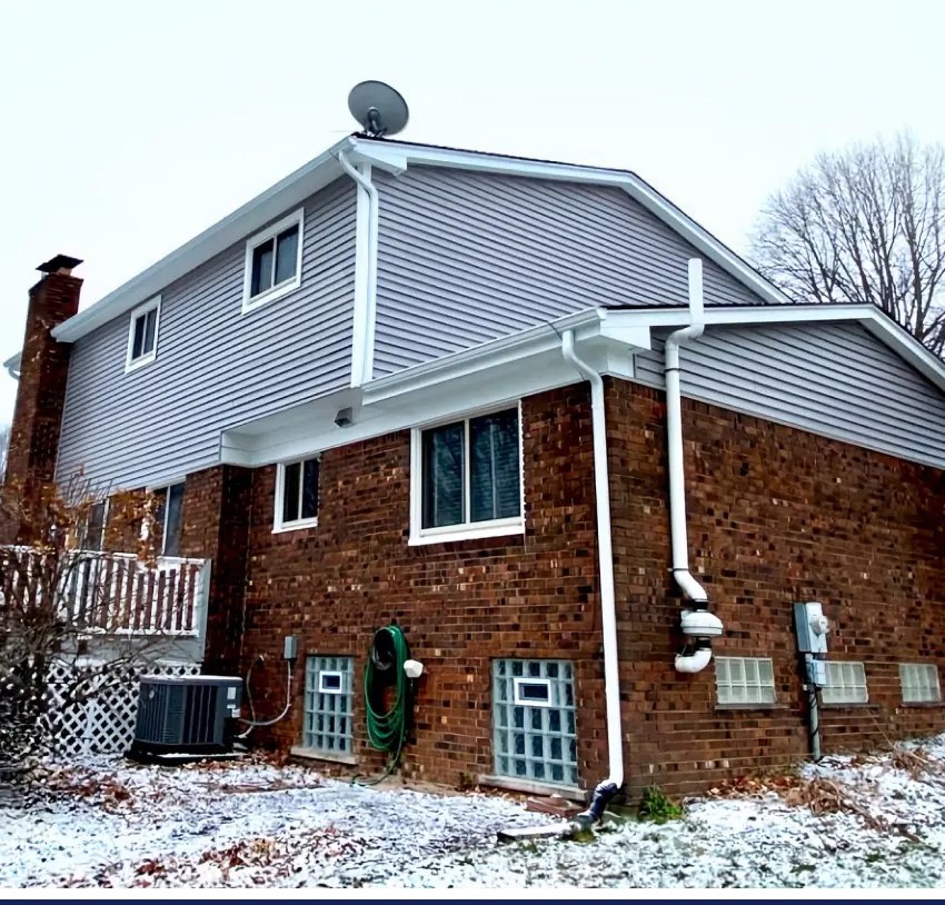 A brick house with a satellite dish undergoing exterior improvement.