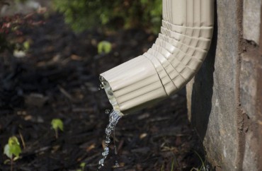 An exterior water pipe coming out of a wall.