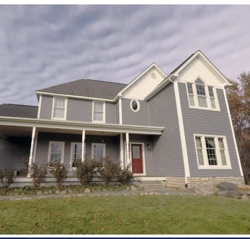 The exterior of a Michigan home with gray siding and white trim.