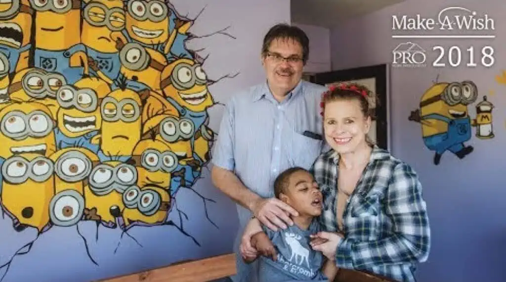 A man and woman are posing in front of a mural of minions in Michigan.