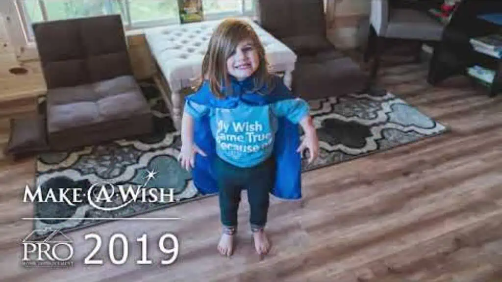 A little girl in a blue cape standing in a Michigan home.