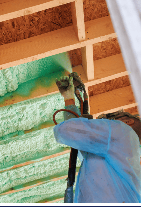 A man is spraying foam insulation on a wooden ceiling in Michigan for home improvement.