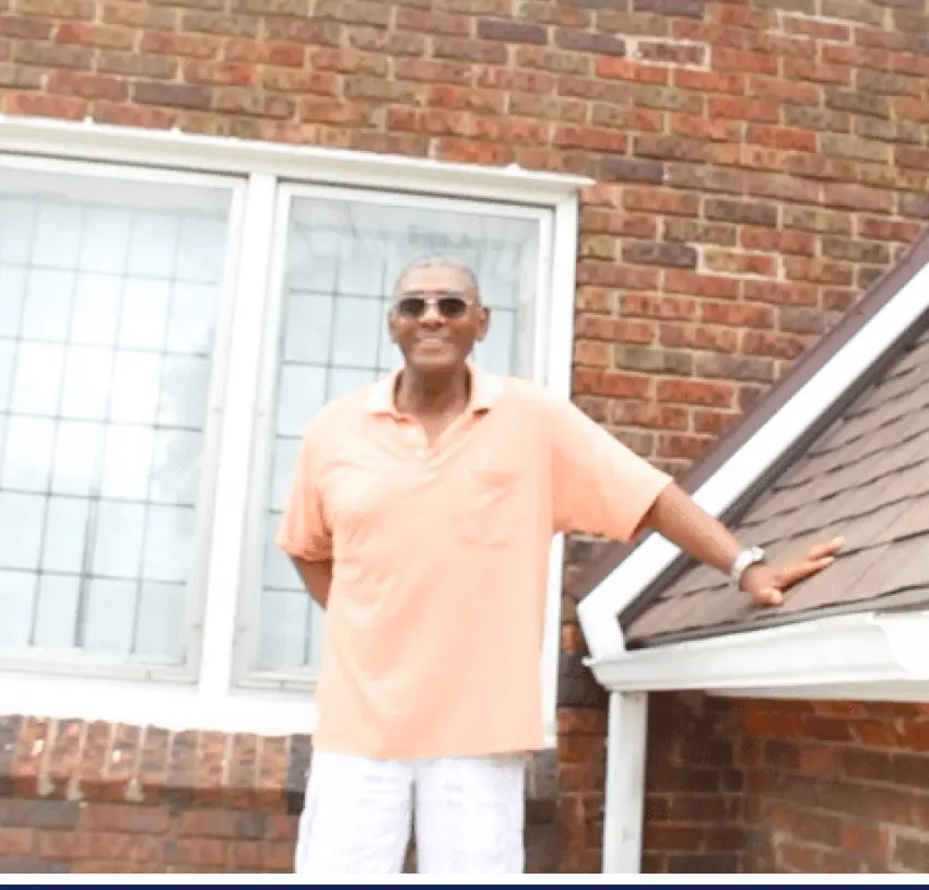 A man standing in front of his home with the text, how to replace a roof.