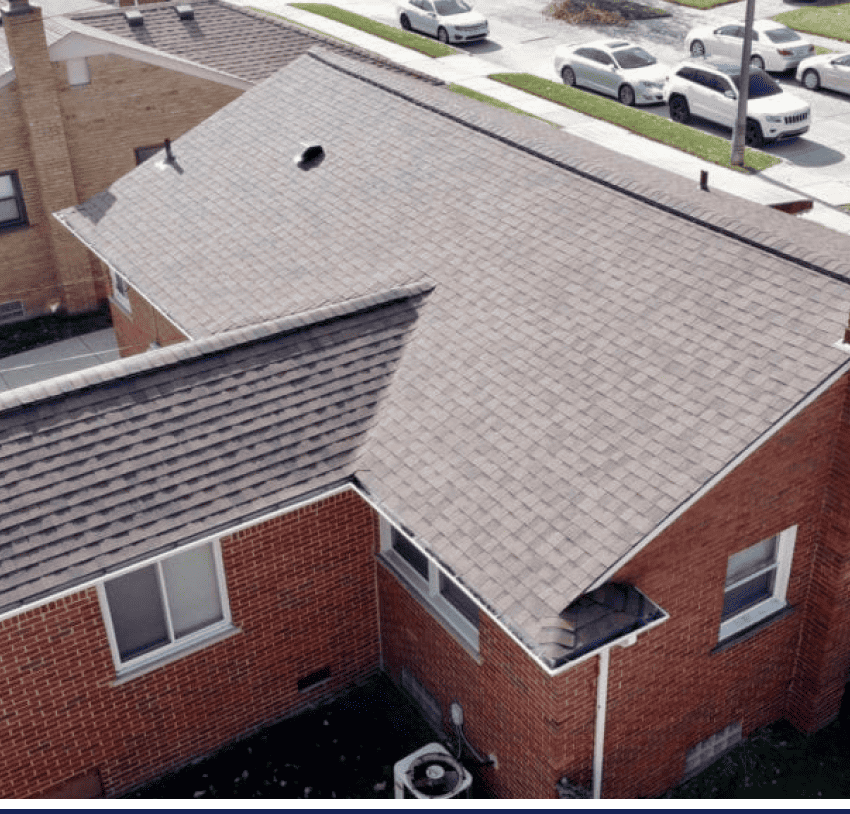 An aerial view of a home with a shingled roof.