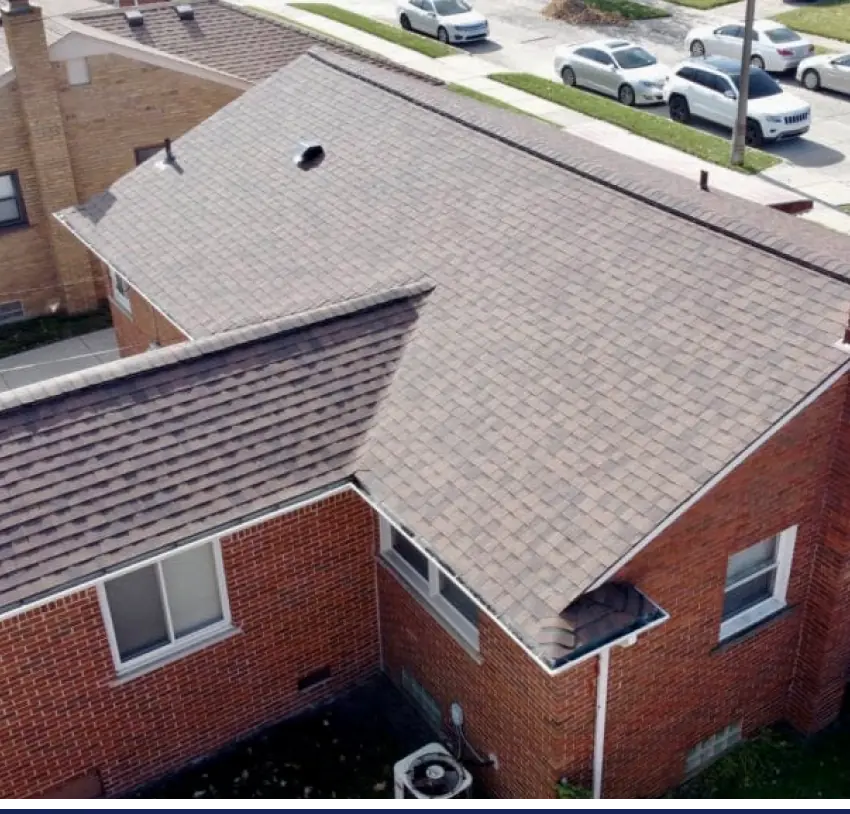 An aerial view of a home with a shingled roof.