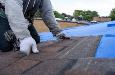 A person installing a roof for an improvement project.