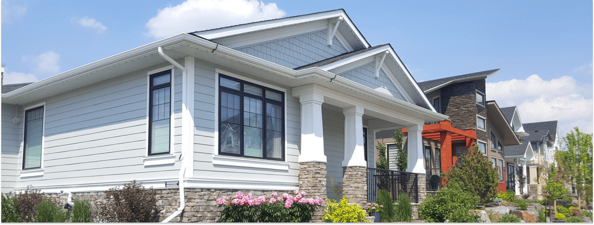 The exterior of a house with white siding and bushes for Financing.