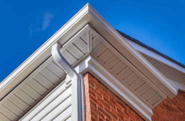 A close up of a residential house with gutters.