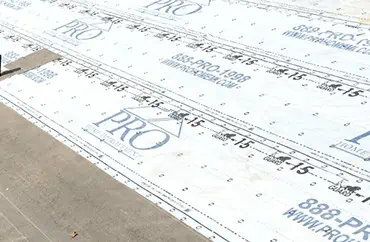 A sheet of insulation is laid out on a concrete floor for a home improvement.