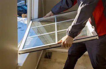 A man opening a window in a room with Grid.