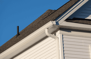 A white gutter with a pipe attached to it for exterior remodeling.
