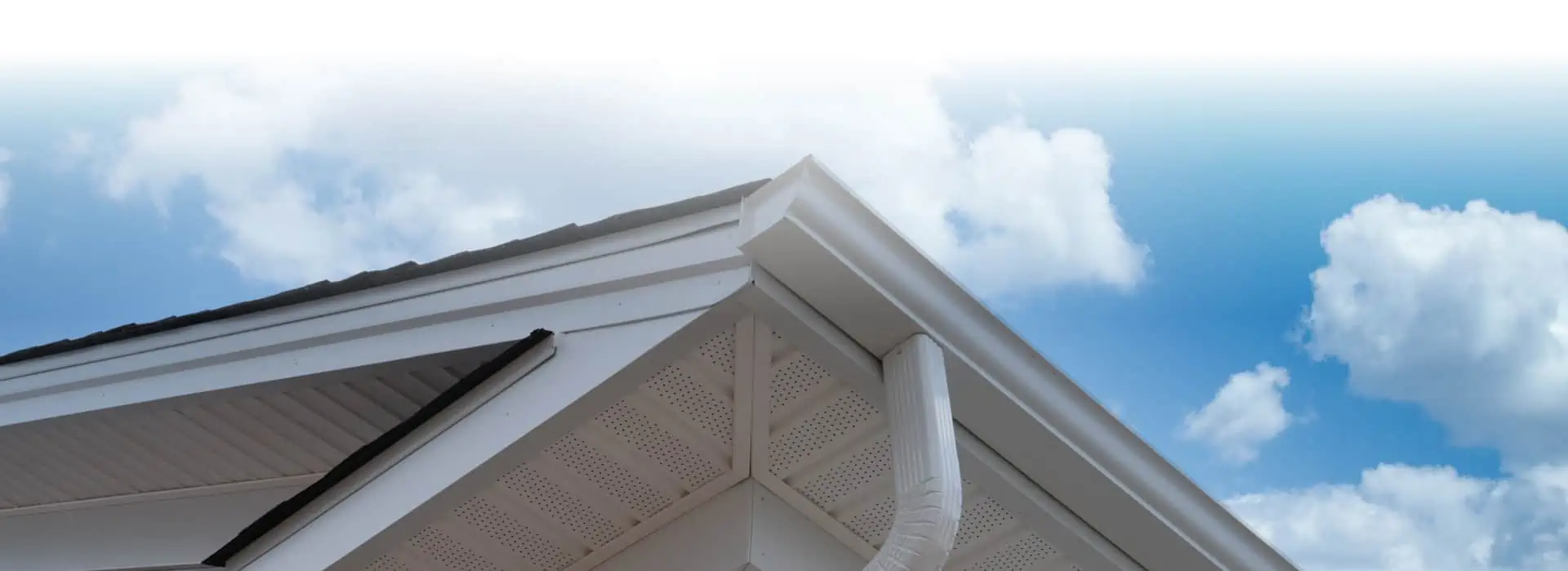 The roof of a house, featuring gutter financing options, with a blue sky in the background.