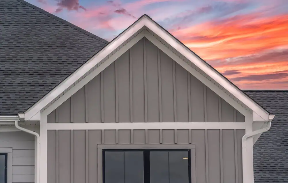 gray board and batten exterior siding with white trim and black windows