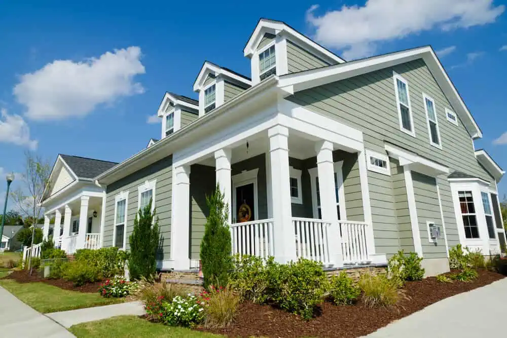 Light olive green wood siding on a craftsman style home in a neighborhood