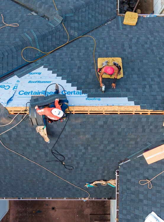 A crew replacing an existing shingle roof system