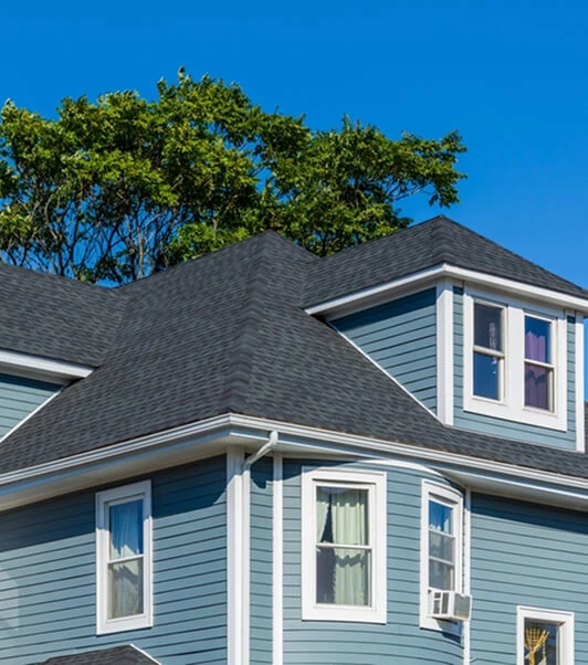 Blue two-story house with new siding, windows, insulation, gutters, and roof repair in Michigan.