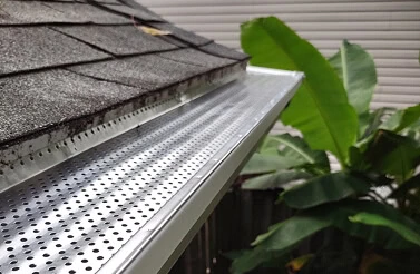 Close-up of Michigan roofing services with new gutter covers, siding, and window repair.